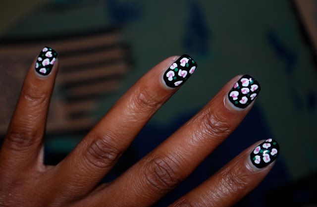 Chic Floral Nail Design with Black Base and Delicate Pink and White Accents