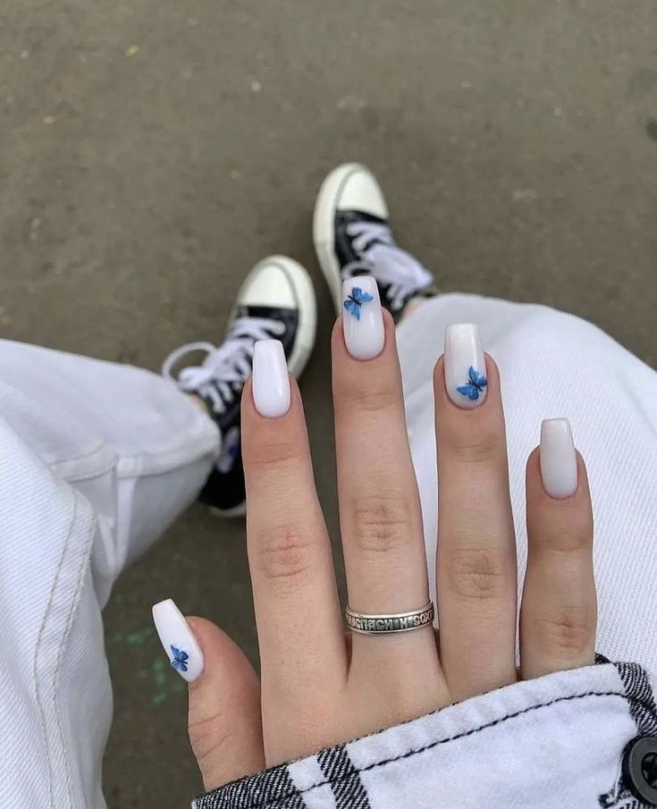 Elegant White Nail Design with Delicate Blue Floral Accents for a Refreshing Look.