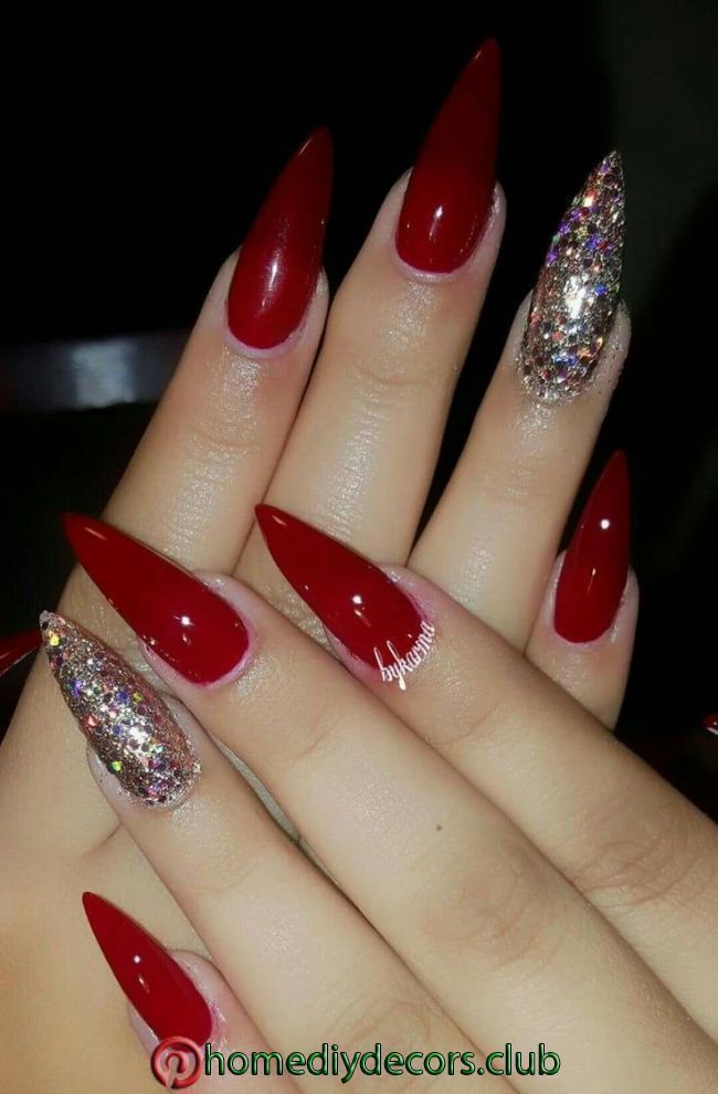 Bold Glamour: Elegant Red Stiletto Nails with Sparkling Glitter Accents.