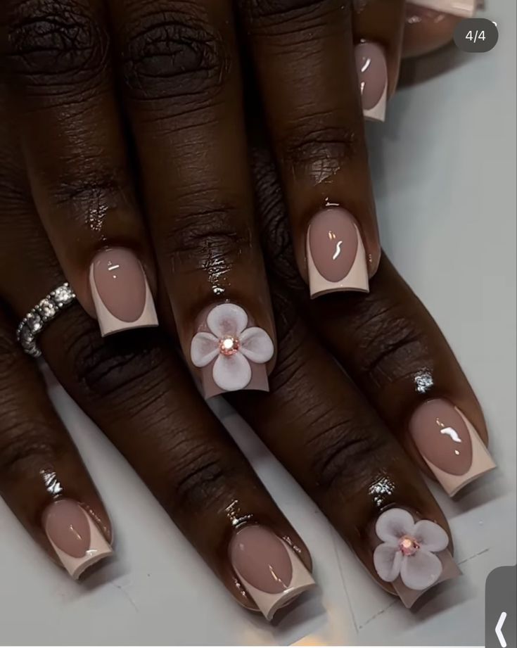 Chic French Manicure: Soft Nude Base with Delicate White Tips and Floral Gem Accents.