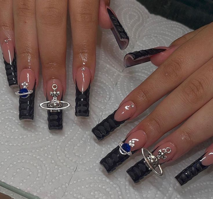 Celestial-Themed Elegant Black Stiletto Nails with Silver and Blue Embellishments.