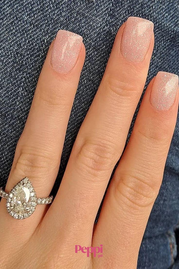 Sophisticated Soft Pink Shimmer Nail Design Complemented by Teardrop Engagement Ring.