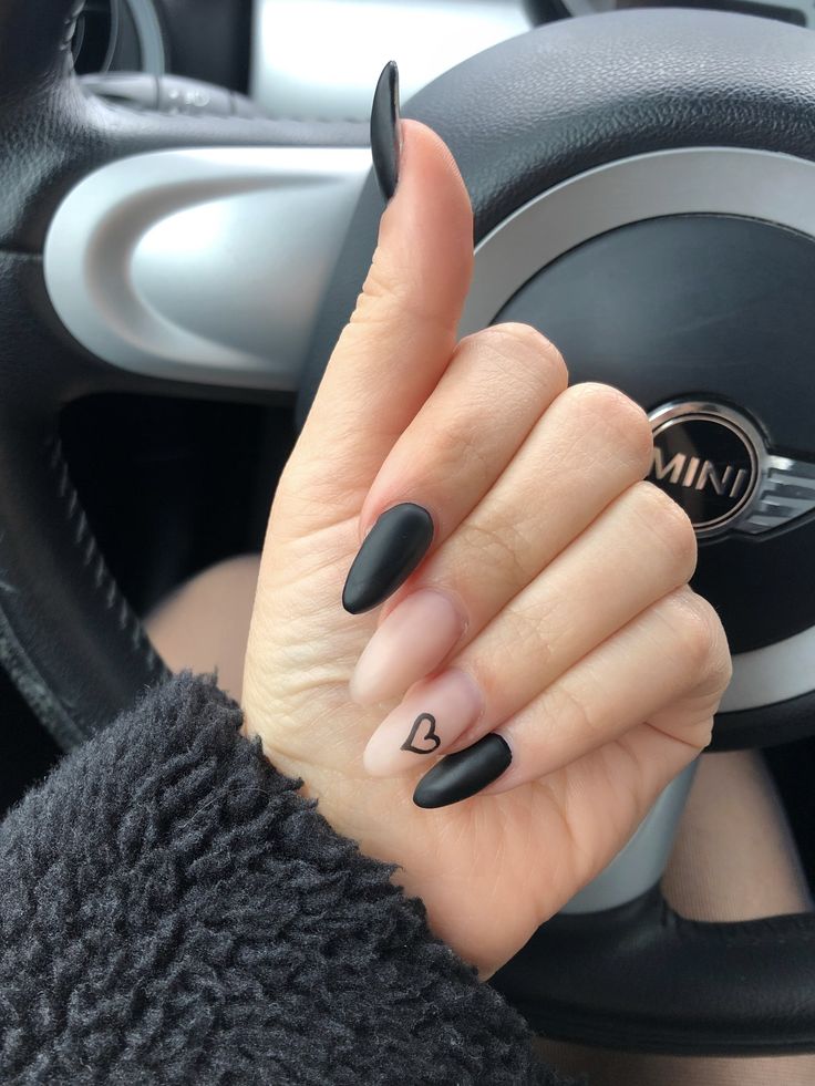 Chic Matte Black and Nude Nail Design with Heart Accent