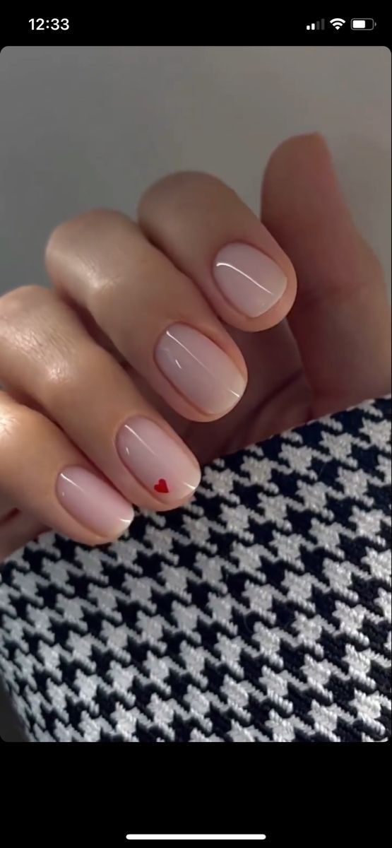 Elegant Nude Nail Design with Subtle Gradient and Playful Red Heart Accent.