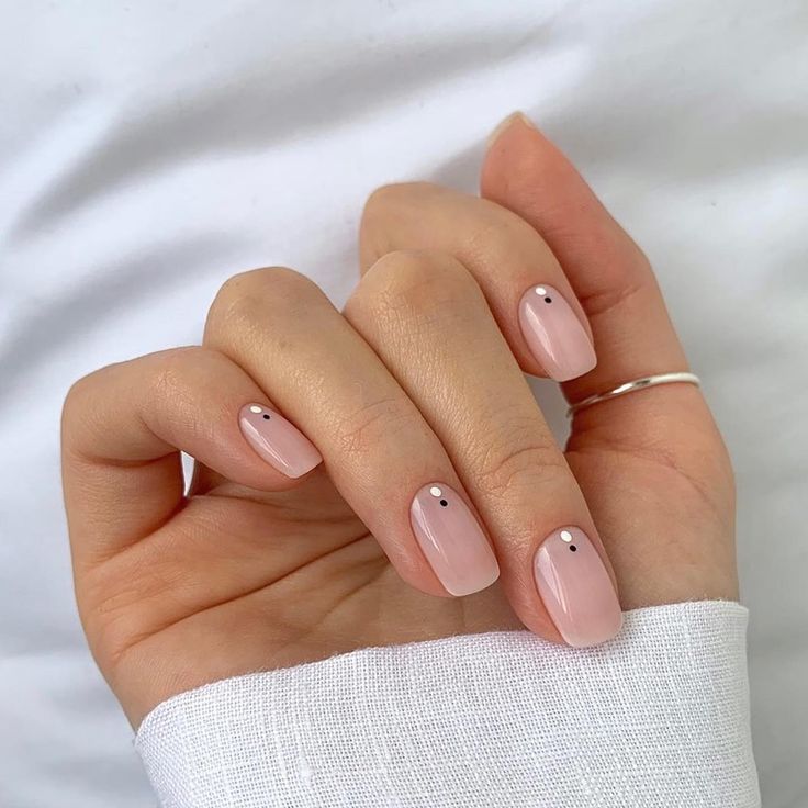 Sophisticated Elegant Nude Nails with Minimalist Black Dot Embellishments.