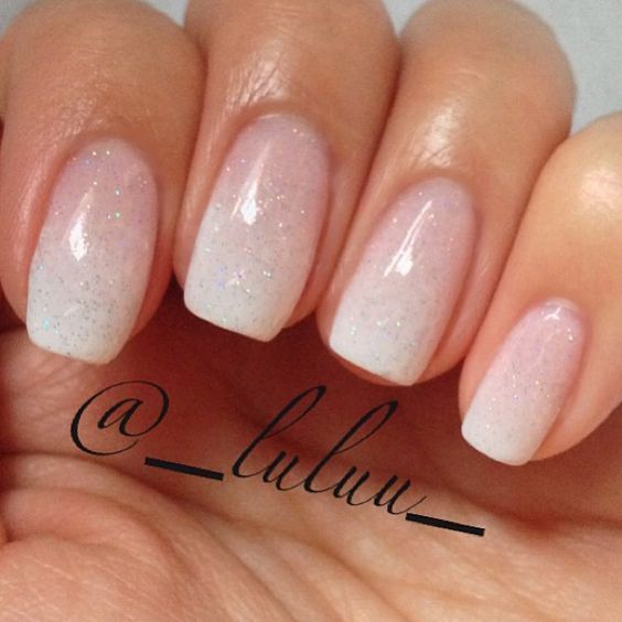 Elegant Ombre Nails: Subtle Sheer Pink to Pale White Gradient with Holographic Sparkle.