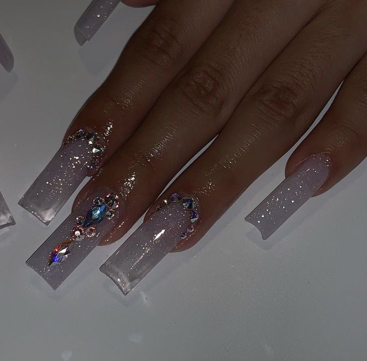 Glamorous Gradient Long Nails with Translucent Sparkle and Intricate Gemstones.