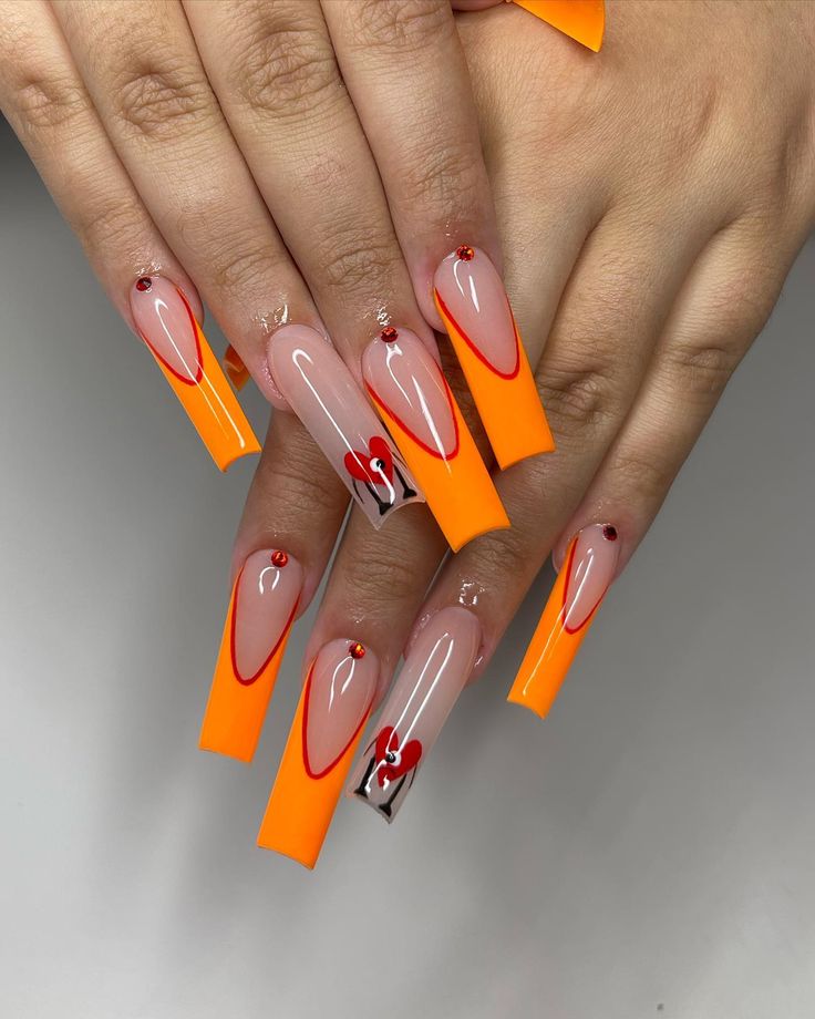 Playful Vibrant Nail Design: Long Square Nails in Orange and Nude with Bold Red Outlines and Glam Embellishments.