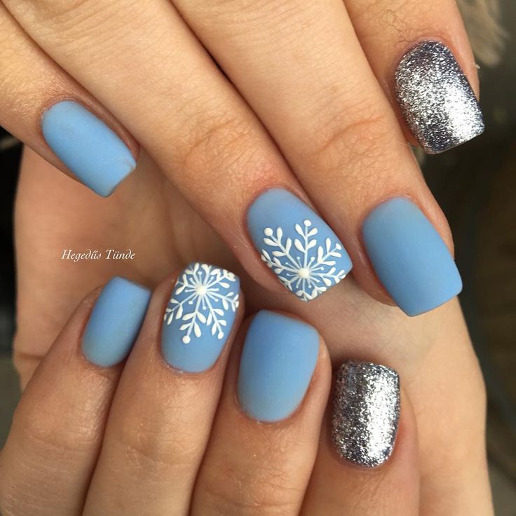 Chic Winter-Inspired Nail Design: Soft Blue Matte with Silver Glitter and Snowflake Accents.