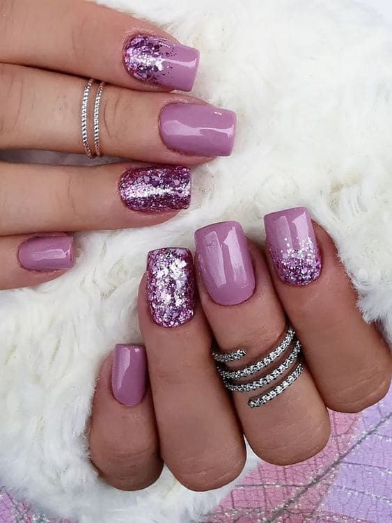 Sophisticated Lavender Nail Design with Glitter Accents and Stylish Silver Rings.