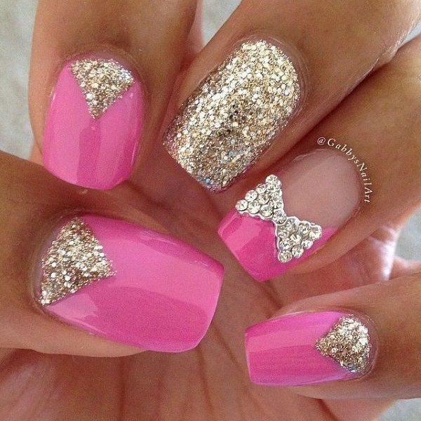 Chic Vibrant Pink Nails with Glittering Gold Accents and Playful Bow Embellishment.