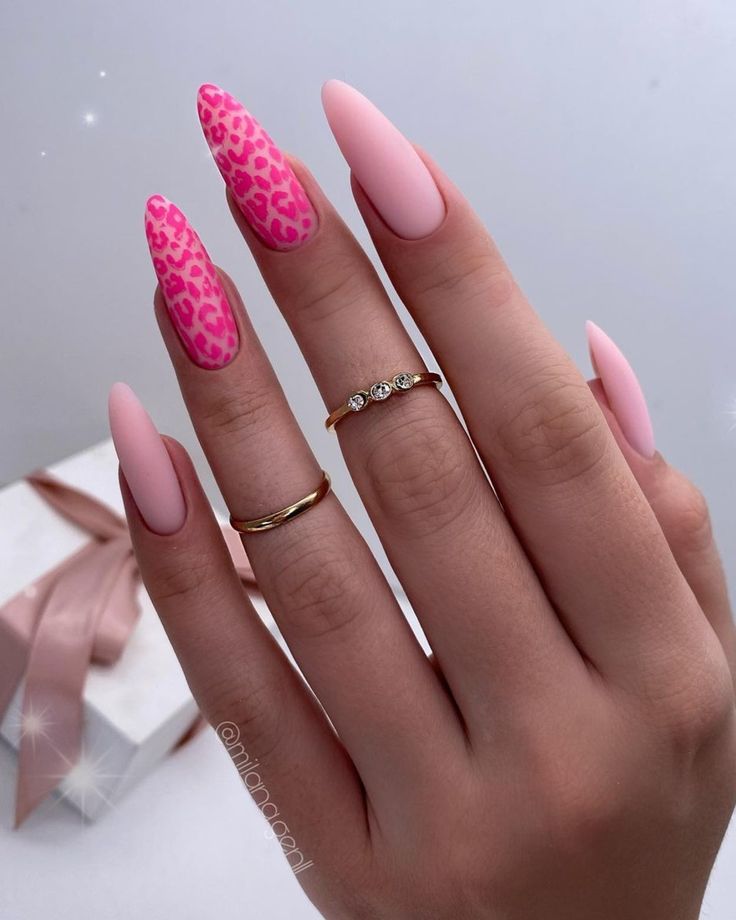 Chic Almond-Shaped Nails with Bold Pink and Leopard Print Designs, Accented by Elegant Gold Rings.