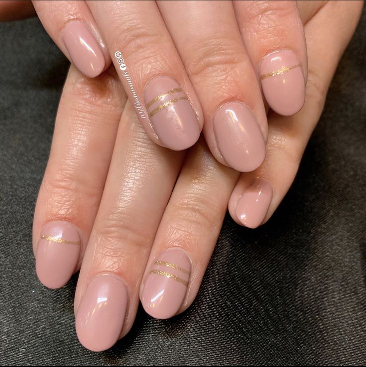 Sophisticated Nude Nail Design with Subtle Gold Stripes for Elevated Elegance.