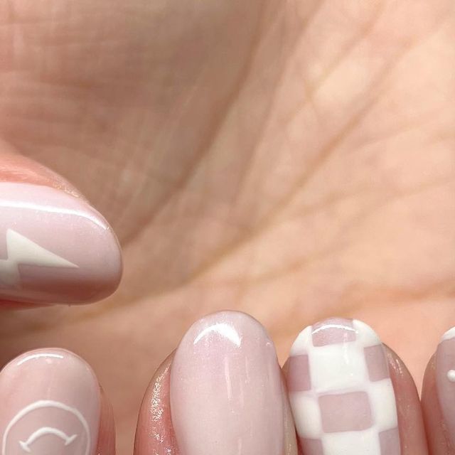 Chic Soft Pink Nail Design with Glossy Finishes and Playful Geometric Patterns.