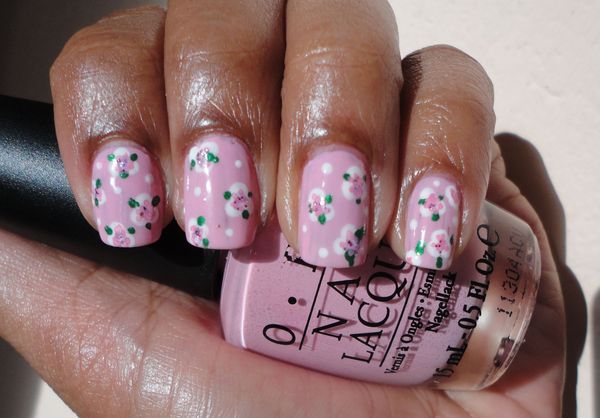 Charming Floral Nail Design: Soft Pink Base with Polka Dots and Rose Accents for a Feminine Spring Look.