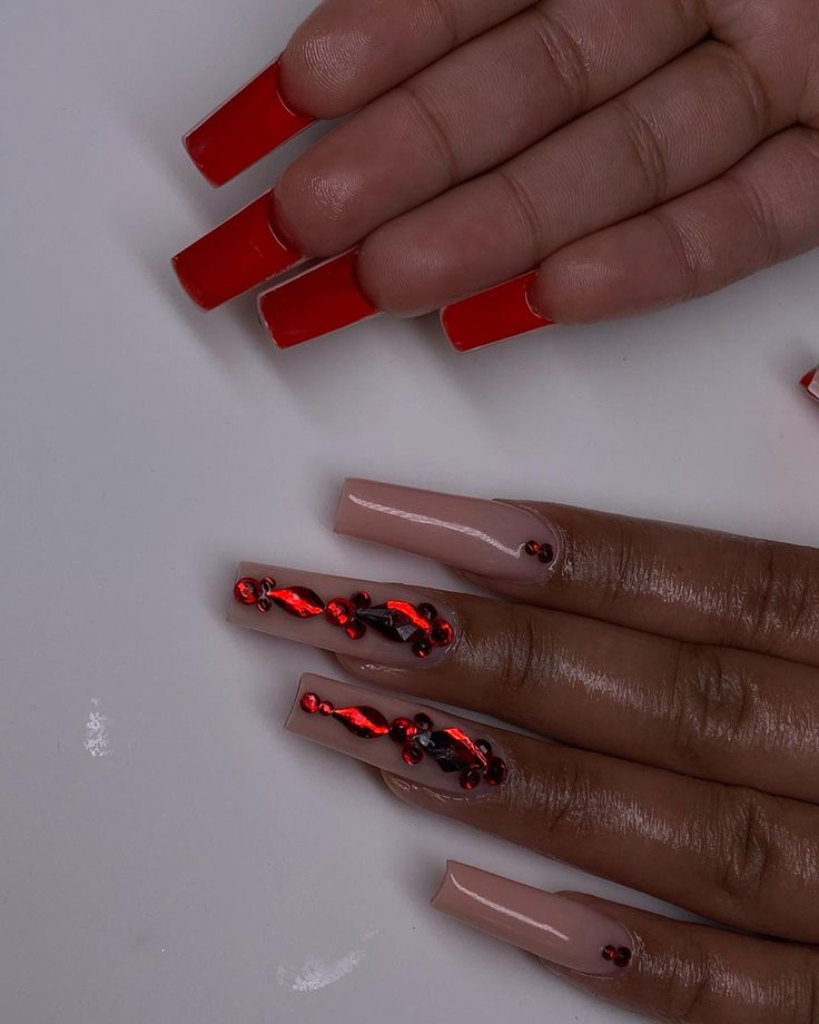 Chic Contrasting Nail Designs: Bold Red Tips, Nude Base, and Elegant Rhinestones.