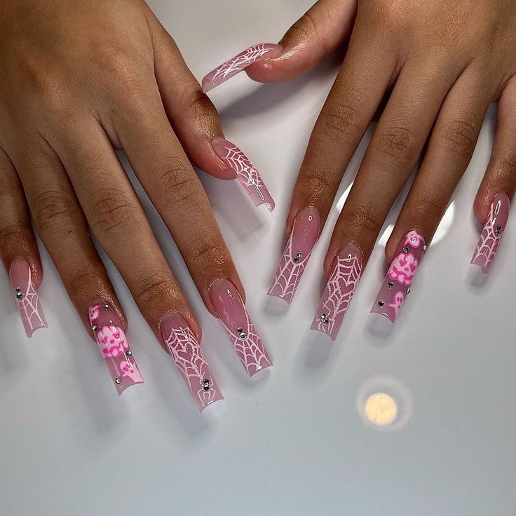 Playful Pastel Spider Web Nail Design with Cute Characters and Rhinestone Accents.