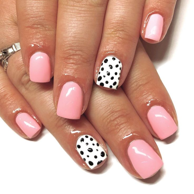 Chic Playful Nail Design with Soft Pink Base and Bold Black and White Polka Dots.