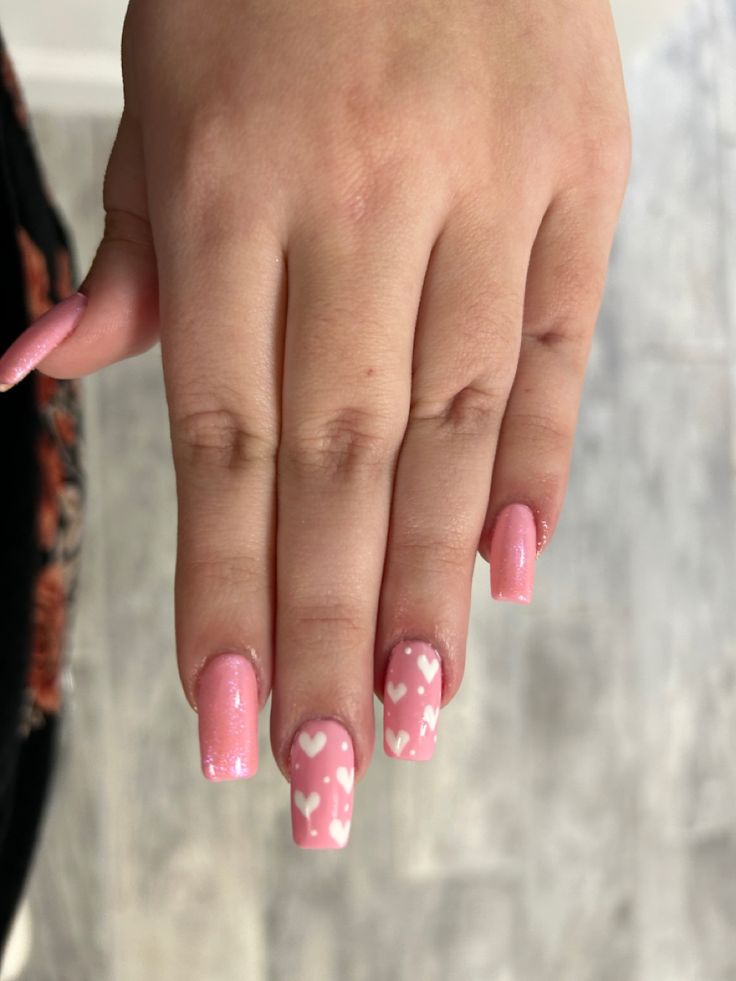 Playful Pink and White Heart Nail Design with Glittery Tips for a Romantic Aesthetic.