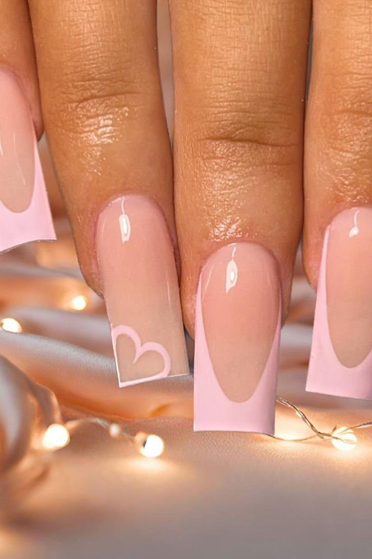 Chic Nude Nail Design with Delicate Pink Accents and Charming Heart Detail.