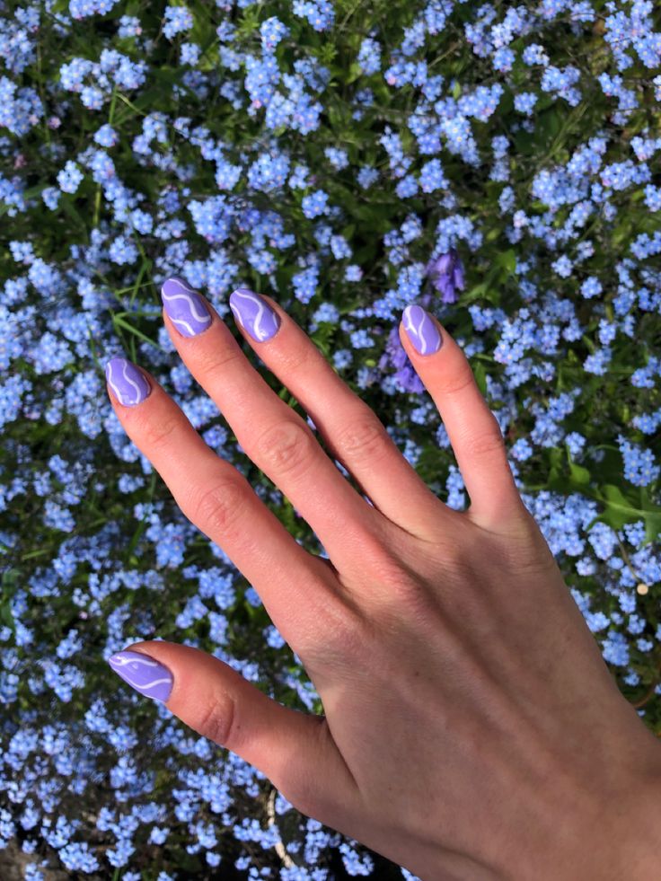 Chic Lavender Nail Design with Abstract White Swirls for a Playful Spring Vibe.