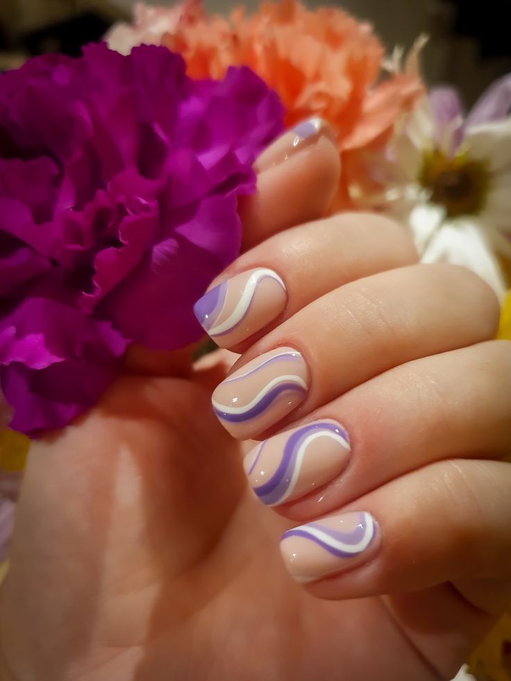 Serene Pastel Nail Design: Wavy Patterns and Floral Accents for a Modern Touch.