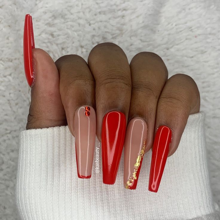 Elegant Bold Red and Soft Nude Nail Design with Gold Accents.