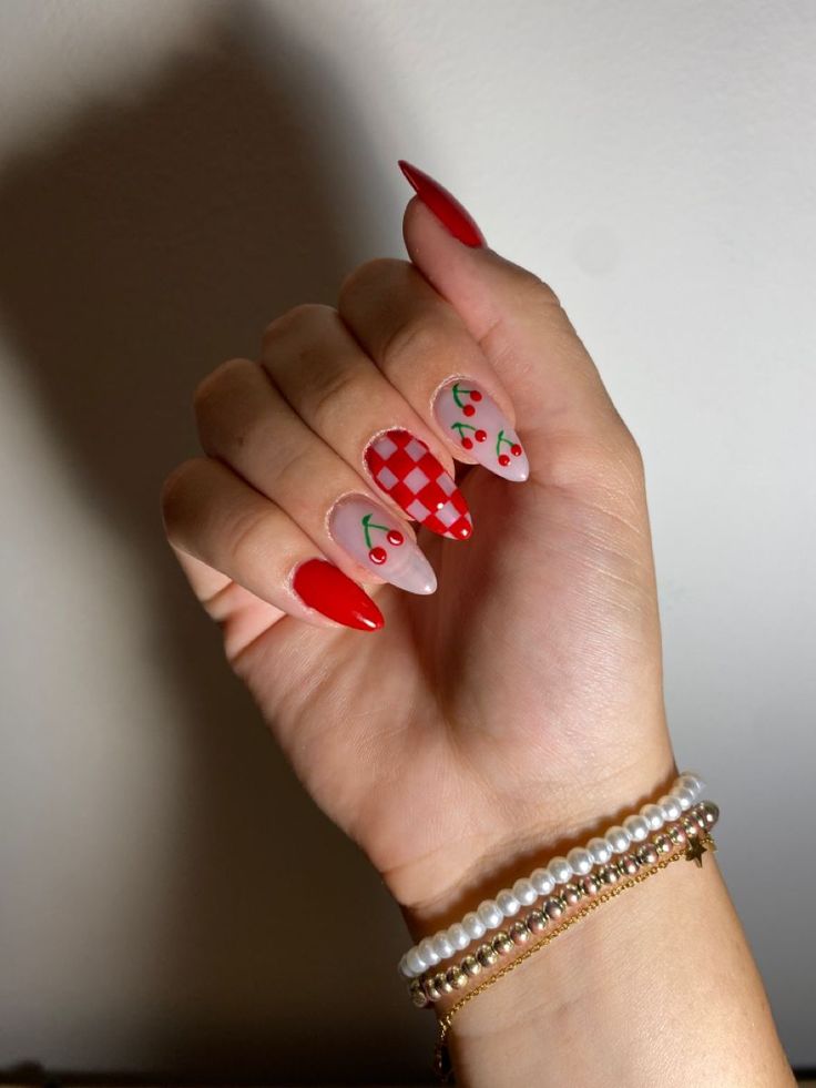 Playful Summer Nail Design: Bold Red with Cherry Motifs and Checkered Patterns on Almond Shaped Nails