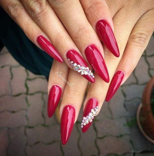 Glamorous Chic Red Stiletto Nails with Sparkling Embellishments for a Sophisticated Look.