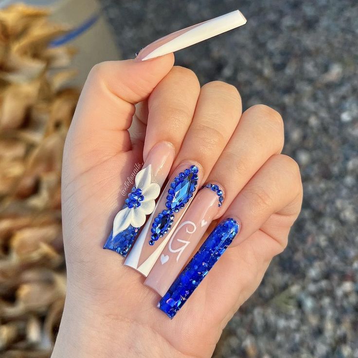 Stunning Vibrant Blue Nail Design with Textured Finishes and Glamorous Embellishments.