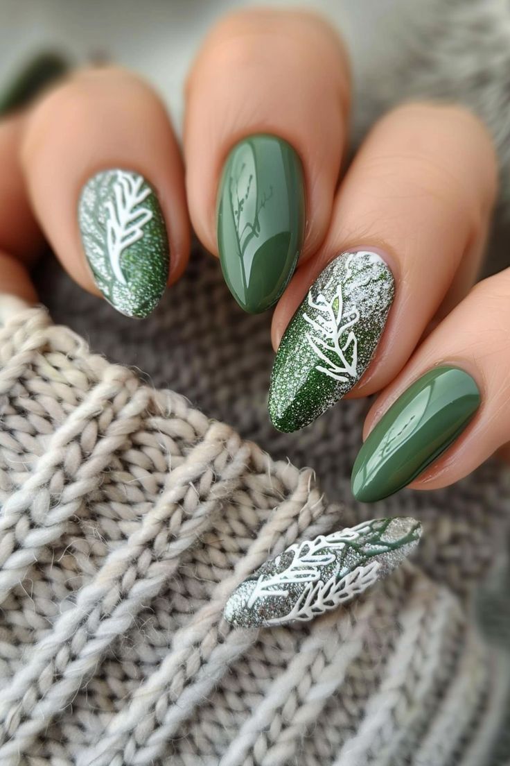 Chic Nature-Inspired Nail Design with Deep Green, Glittery Silver, and Intricate White Patterns.