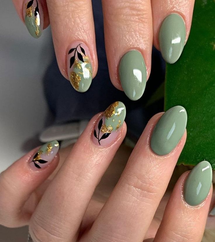 Chic Green Nail Design with Intricate Black Leaves and Gold Glitter Accents