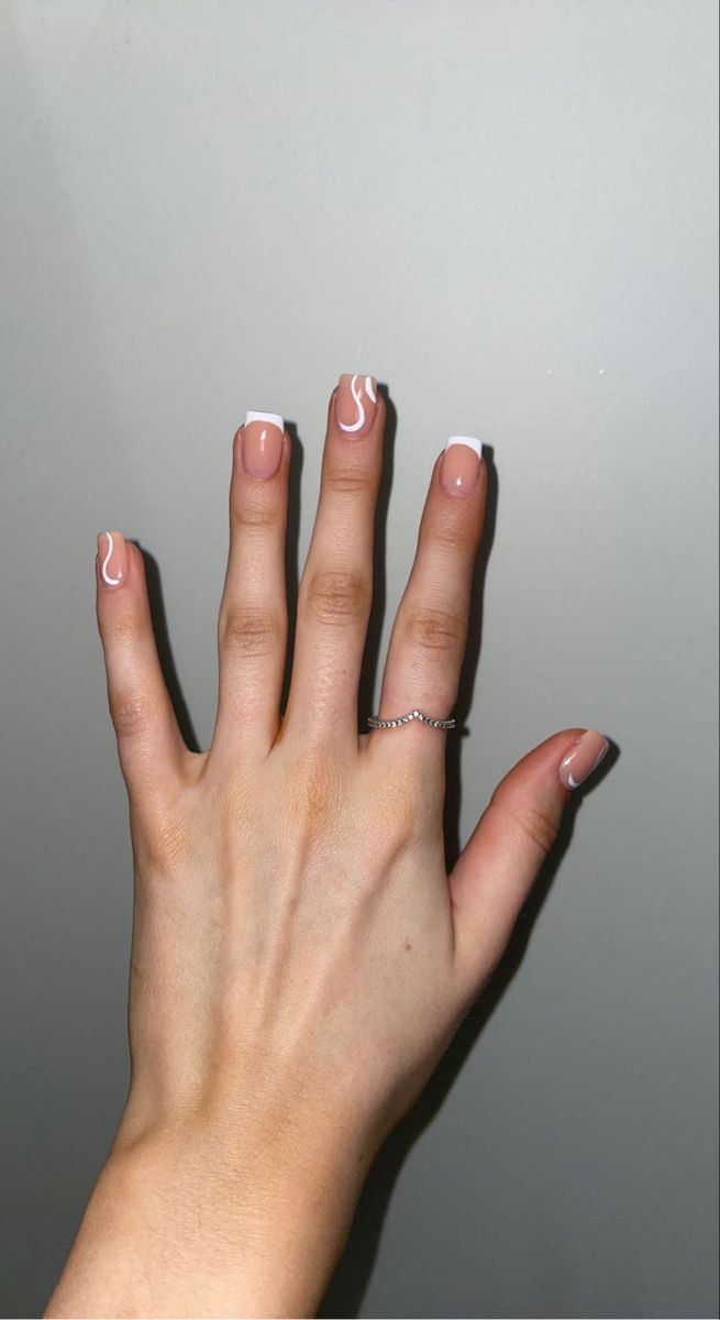 Chic Nude Nail Design with White Tips and Artistic Swirls for Any Occasion.