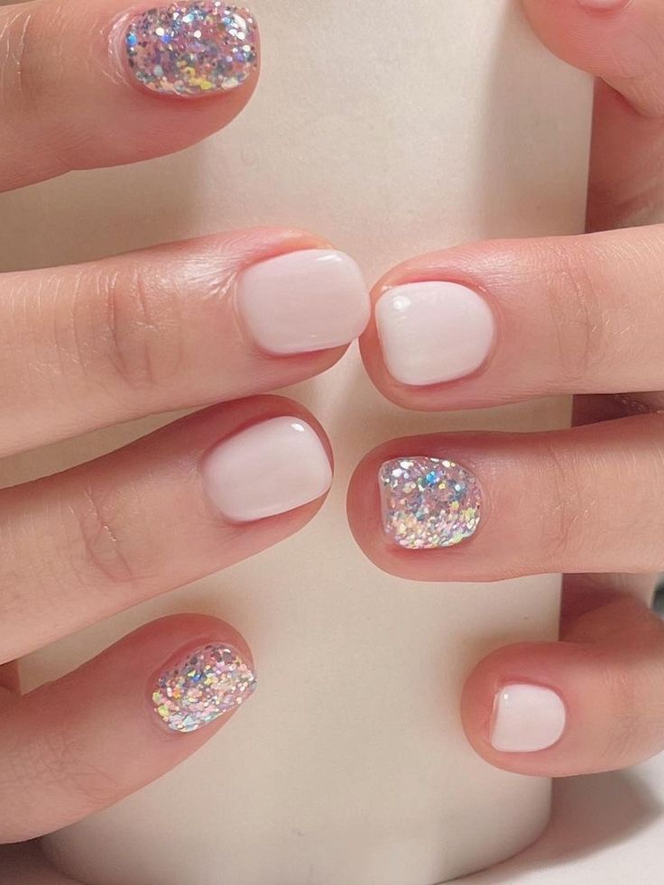 Chic White Nail Design with Sparkling Glitter Accents for Elegant Glamour.