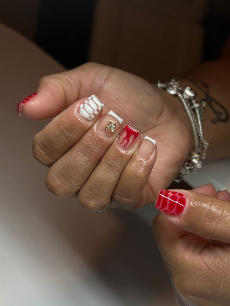 Chic Red and White Festive Nail Design with Abstract Drips and Elegant Accents.