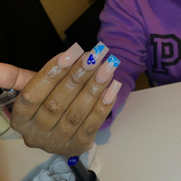 Elegant Nude Nails with Vibrant Blue Accents and Intricate Patterns.