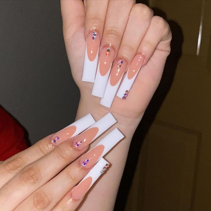 Chic Nail Design: Striking Nude and Bright White Tones with Sparkling Gem Accents.