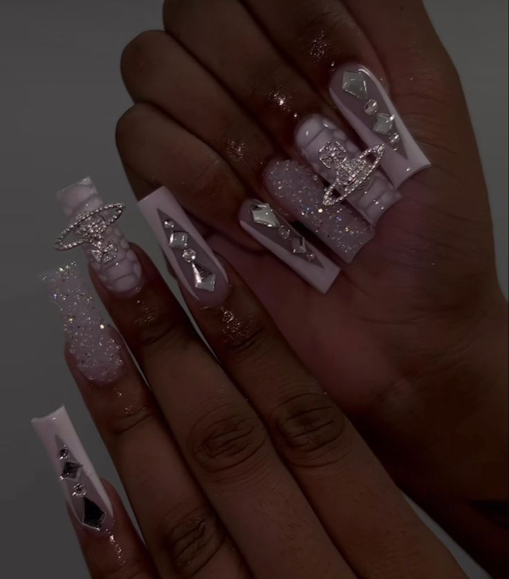 Elegant Pink Nail Design with Sparkling Accents and Unique Embellishments.