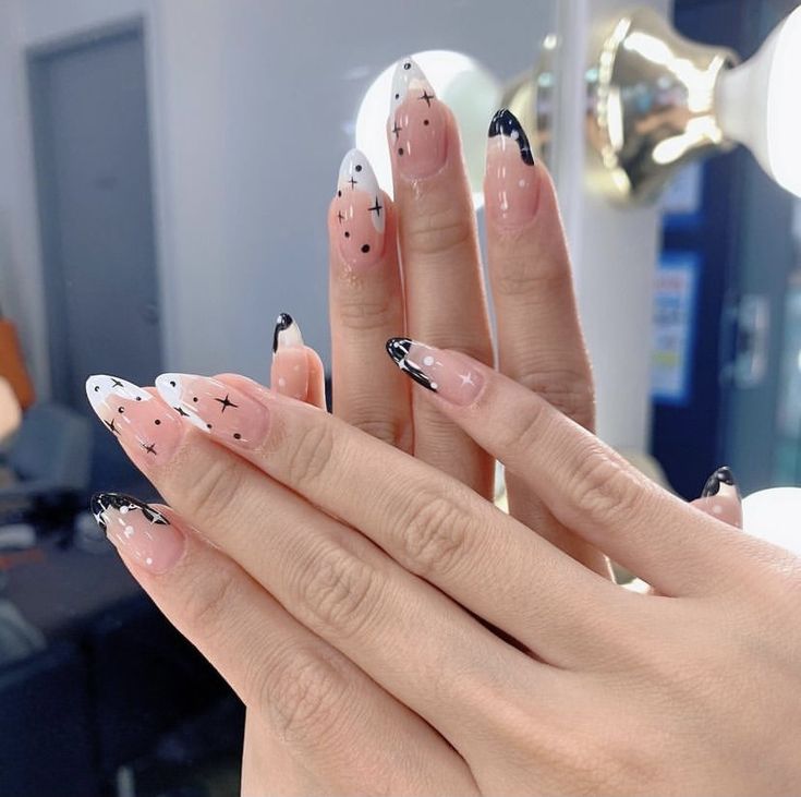 Chic French Tip Nail Design with Nude Base, White Tips, and Playful Black Star Accents.