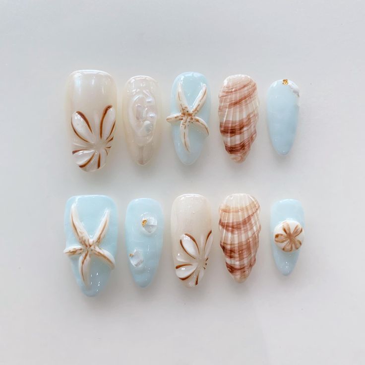 Serene Ocean-Inspired Nail Design with Starfish and Seashell Motifs in Soft Blues and Creamy Whites.