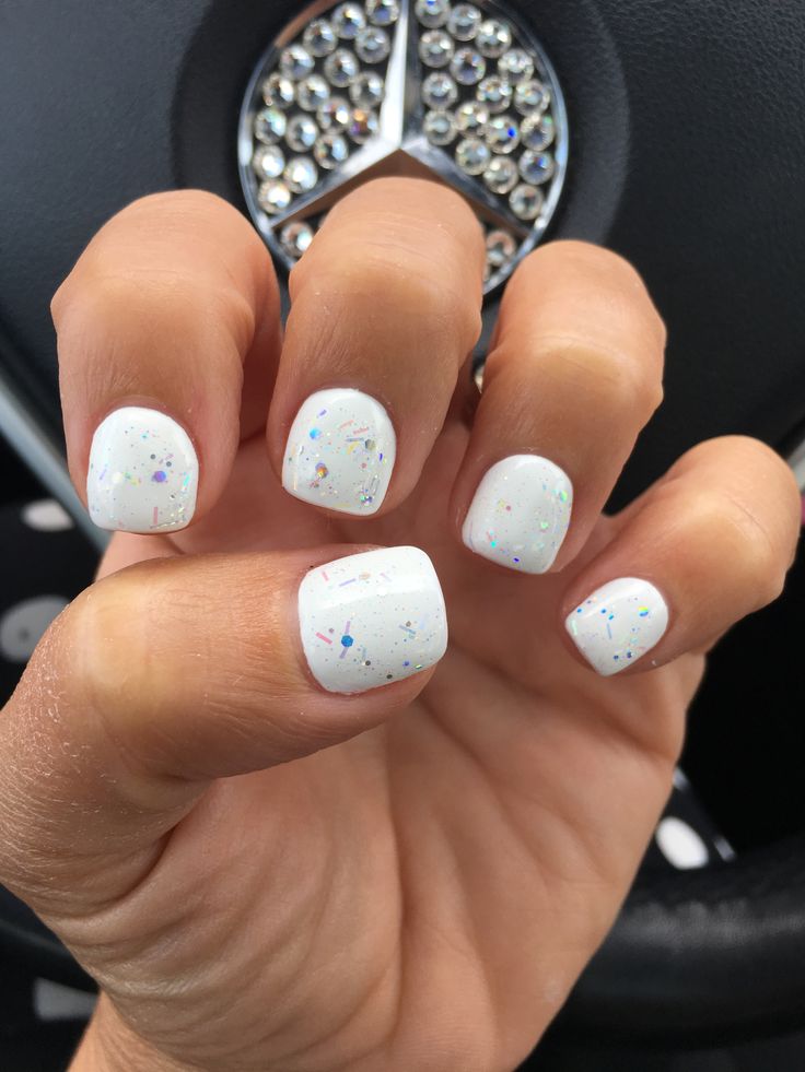 Elegant Chic White Manicure with Glossy Finish and Iridescent Glitter Accents