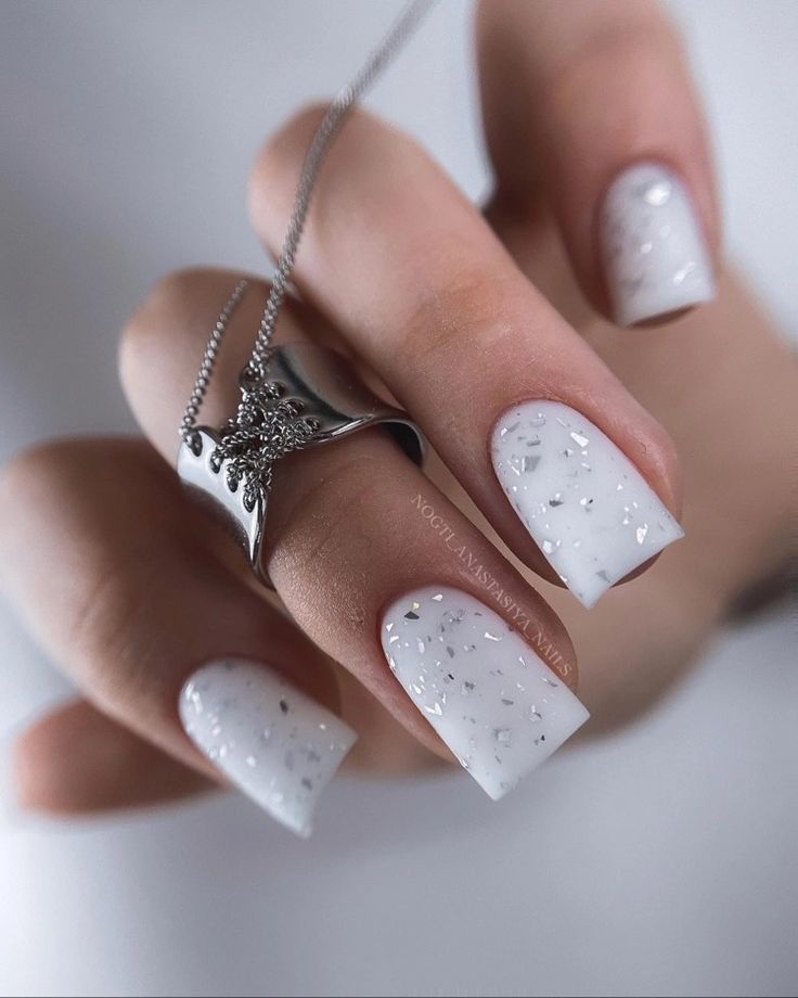 Chic Elegance: Glossy White Nails Enhanced with Sparkling Rhinestones and Silver Jewelry.