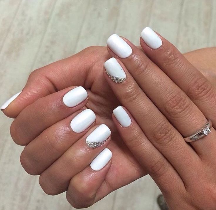 Chic Matte White Nail Design with Subtle Rhinestone Embellishments