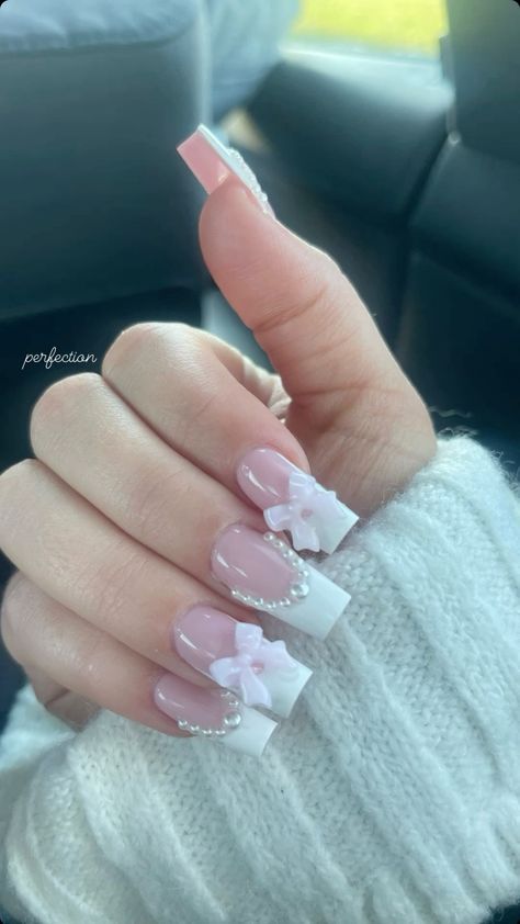 Charming French Tip Nail Design with Feminine Embellishments.