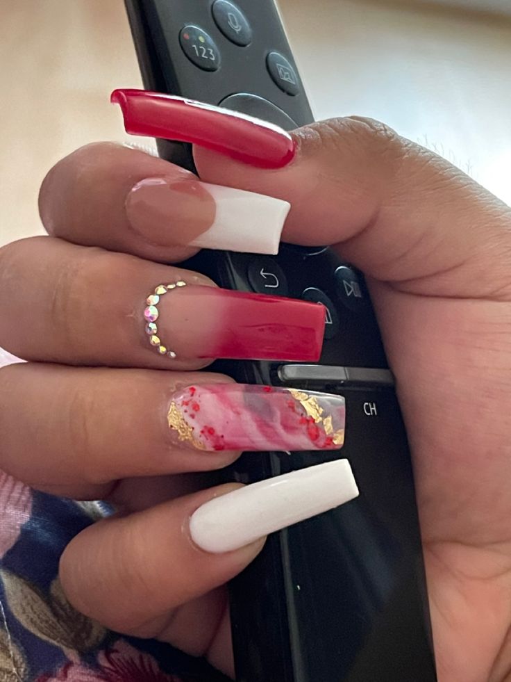 Elegant Bold Red and White Nail Design with Marble Effect and Rhinestone Accents.