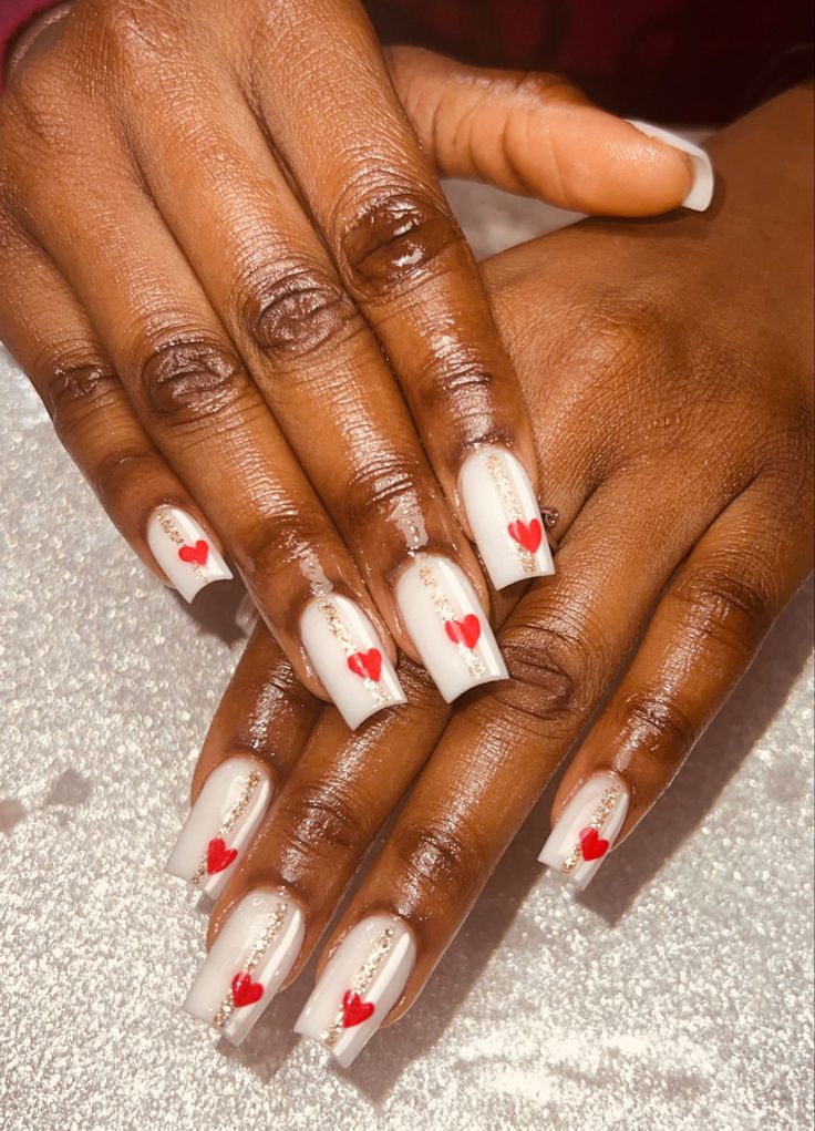 Elegant Neutral Nail Design with Red Heart Accents and Silver Embellishments.