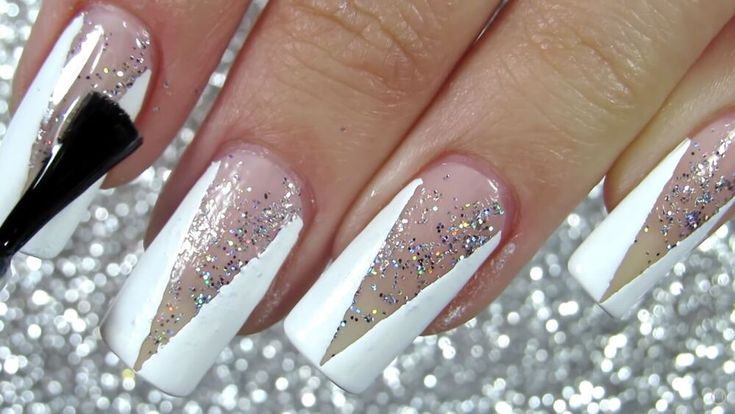 Chic White and Nude Nail Design with Geometric Patterns and Glitter Accents.