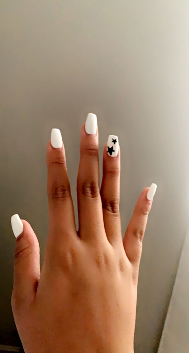 Chic White Nail Design with Playful Black Star Accents