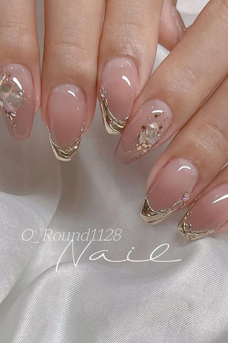 Sophisticated Nude Nail Design with Glossy Golden Tips and Sparkling Gems.