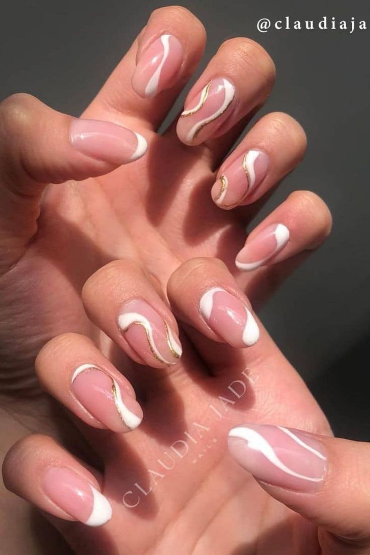 Chic Nude Nail Design with White Swirls and Golden Accents